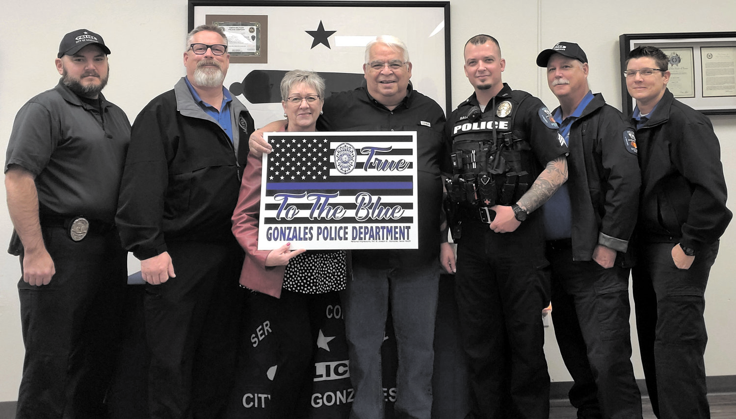 Personal Impressions owners Andy and Cindy Rodriguez give specially designed signs with “True to the Blue” to the Gonzales Police Department.